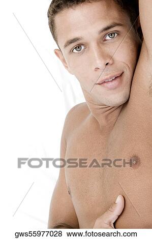 Stock Photo - Portrait of a young man lying on a bed. Fotosearch