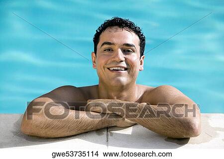 Portrait of a young man smiling in a swimming pool View Large Photo Image Picture - Portrait of a young man smiling in a swimming pool. Fotosearch