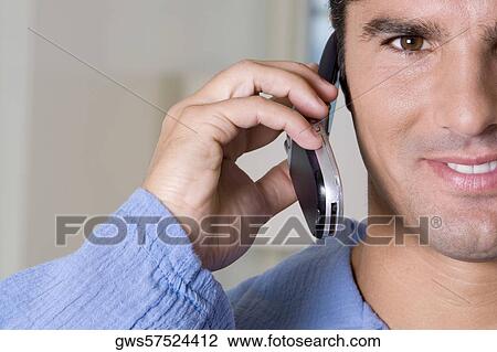 Stock Image - Portrait of a young man talking on a mobile phone. Fotosearch