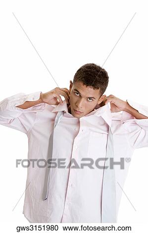 Portrait of a young man tying a necktie View Large Photo Image Stock Image - Portrait of a young man tying a necktie. Fotosearch