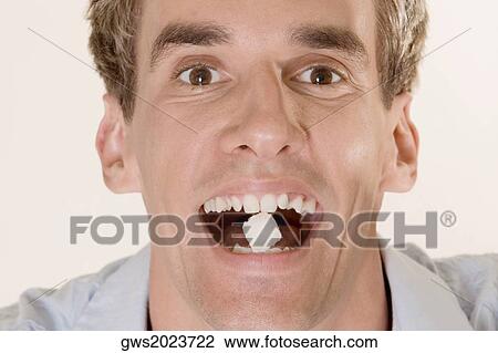 Portrait of a young man with candy in his mouth View Large Photo Image Stock Image - Portrait of a young man with candy in his mouth. Fotosearch