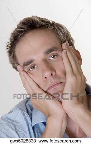 Portrait of a young man with his hands on his face View Large Photo Image Stock Image - Portrait of a young man with his hands on his face. Fotosearch