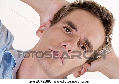 Portrait of a young man with his hands behind his head View Large Photo Image Stock Photograph - Portrait of a young man with his hands behind his head. Fotosearch