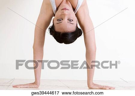 Portrait of a young woman doing the handstand View Large Photo Image Stock Photo - Portrait of a young woman doing the handstand. Fotosearch