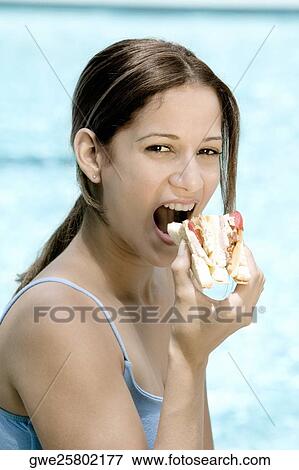 Portrait of a young woman eating a sandwich View Large Photo Image Stock Photo - Portrait of a young woman eating a sandwich. Fotosearch