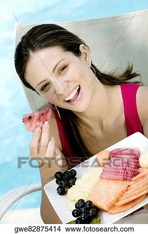 Portrait of a young woman eating fruit salad View Large Photo Image Picture - Portrait of a young woman eating fruit salad. Fotosearch