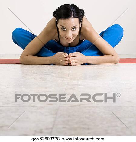 Portrait of a young woman exercising on an exercising mat View Large Photo Image Stock Photo - Portrait of a young woman exercising on an exercising mat. Fotosearch