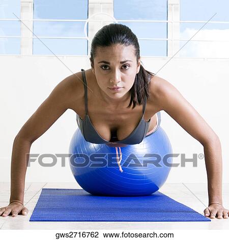 Portrait of a young woman exercising with a fitness ball View Large Photo Image Stock Image - Portrait of a young woman exercising with a fitness ball. Fotosearch