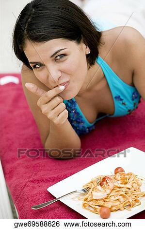 Portrait of a young woman having a meal View Large Photo Image Stock Photograph - Portrait of a young woman having a meal. Fotosearch