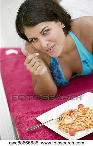 Portrait of a young woman having a meal View Large Photo Image Stock Photograph - Portrait of a young woman having a meal. Fotosearch