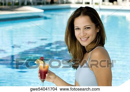 Portrait of a young woman holding a glass of juice View Large Photo Image Picture - Portrait of a young woman holding a glass of juice. Fotosearch