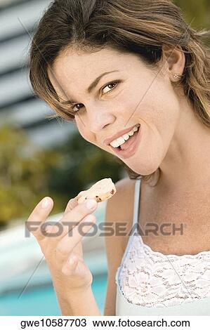 Portrait of a young woman holding a cookie View Large Photo Image Stock Image - Portrait of a young woman holding a cookie. Fotosearch