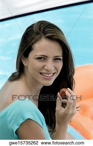 Portrait of a young woman holding a tomato View Large Photo Image Stock Image - Portrait of a young woman holding a tomato. Fotosearch