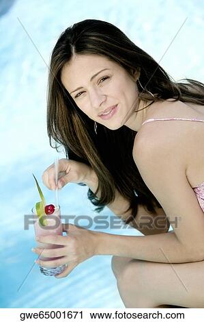 Portrait of a young woman holding a glass of juice View Large Photo Image Stock Image - Portrait of a young woman holding a glass of juice. Fotosearch