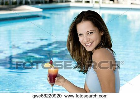 Stock Image - Portrait of a young woman holding a glass of juice. Fotosearch