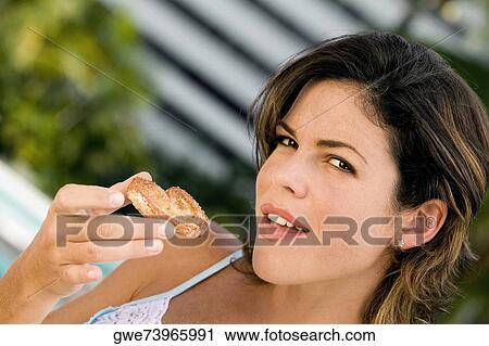 Portrait of a young woman holding a cookie View Large Photo Image Stock Image - Portrait of a young woman holding a cookie. Fotosearch
