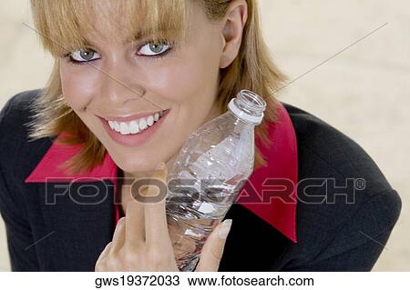 Portrait of a young woman holding a bottle of water View Large Photo Image Stock Image - Portrait of a young woman holding a bottle of water. Fotosearch