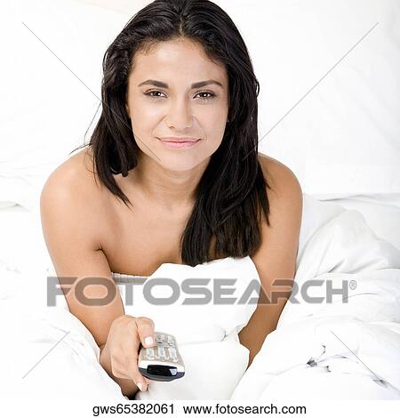 Portrait of a young woman holding a remote control View Large Photo Image Stock Image - Portrait of a young woman holding a remote control. Fotosearch