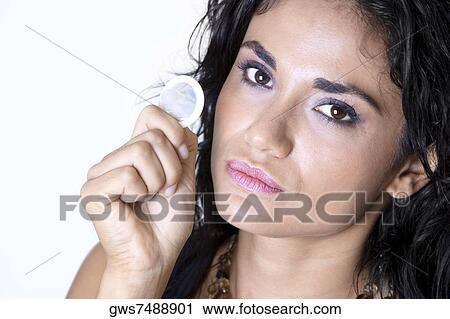 Stock Image - Portrait of a young woman holding a condom. Fotosearch