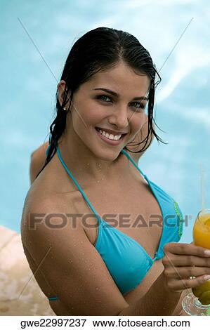 Portrait of a young woman holding a drink View Large Photo Image Stock Photo - Portrait of a young woman holding a drink. Fotosearch
