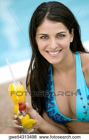 Portrait of a young woman holding a drink View Large Photo Image Stock Photo - Portrait of a young woman holding a drink. Fotosearch