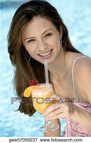Portrait of a young woman holding a glass of juice View Large Photo Image Stock Photo - Portrait of a young woman holding a glass of juice. Fotosearch