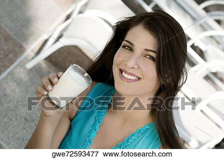Stock Photo - Portrait of a young woman holding a glass of milk. Fotosearch