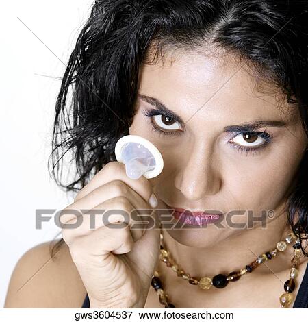 Stock Photo - Portrait of a young woman holding a condom. Fotosearch