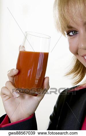 Stock Photo - Portrait of a young woman holding a glass of juice. Fotosearch