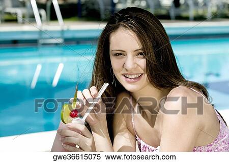 Portrait of a young woman holding a glass of juice View Large Photo Image Stock Photography - Portrait of a young woman holding a glass of juice. Fotosearch