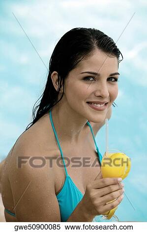 Portrait of a young woman holding a drink View Large Photo Image Stock Photography - Portrait of a young woman holding a drink. Fotosearch