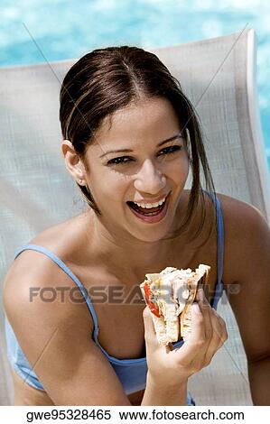 Portrait of a young woman holding a sandwich View Large Photo Image Stock Photography - Portrait of a young woman holding a sandwich. Fotosearch