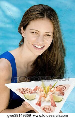 Portrait of a young woman holding a tray View Large Photo Image Stock Photo - Portrait of a young woman holding a tray. Fotosearch