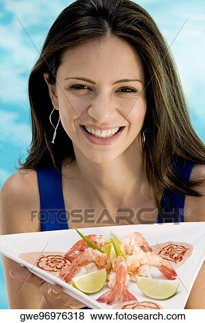 Stock Photo - Portrait of a young woman holding a tray. Fotosearch