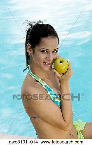 Portrait of a young woman holding an apple View Large Photo Image Picture - Portrait of a young woman holding an apple. Fotosearch
