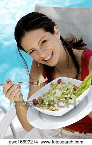 Picture - Portrait of a young woman holding food in a tray. Fotosearch
