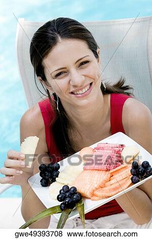 Portrait of a young woman holding food in a tray View Large Photo Image Stock Photo - Portrait of a young woman holding food in a tray. Fotosearch