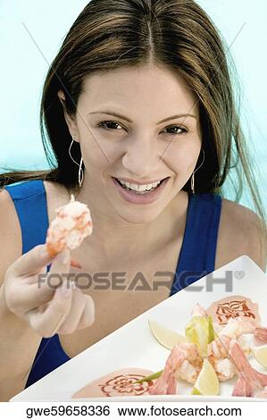 Portrait of a young woman holding food in a tray View Large Photo Image Stock Photograph - Portrait of a young woman holding food in a tray. Fotosearch