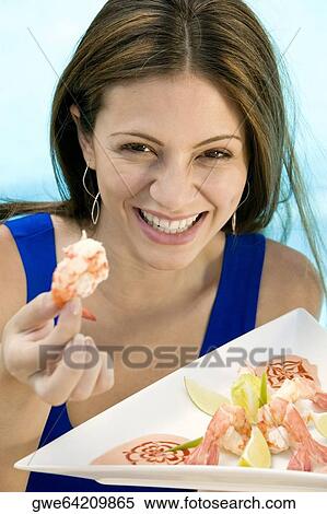 Portrait of a young woman holding food in a tray View Large Photo Image Stock Photography - Portrait of a young woman holding food in a tray. Fotosearch