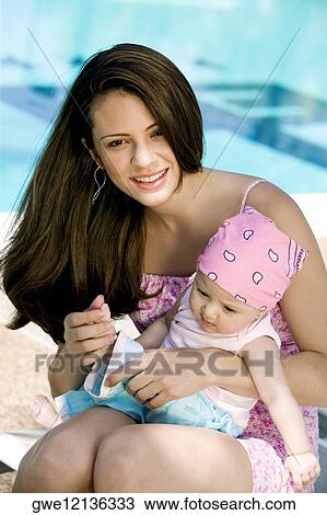 Portrait of a young woman holding her daughter View Large Photo Image Stock Image - Portrait of a young woman holding her daughter. Fotosearch