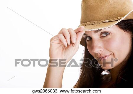 Portrait of a young woman holding the tip of her hat View Large Photo Image Stock Image - Portrait of a young woman holding the tip of her hat. Fotosearch