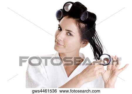 Portrait of a young woman putting a curler in her hair View Large Photo Image Stock Photograph - Portrait of a young woman putting a curler in her hair. Fotosearch