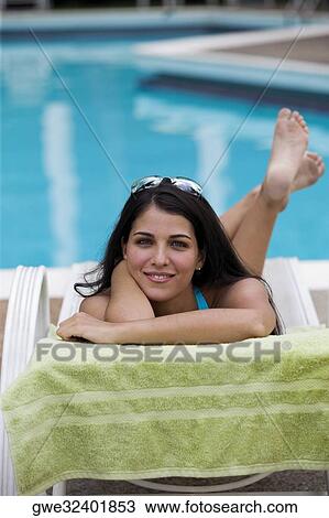 Portrait of a young woman relaxing on a lounge chair View Large Photo Image Stock Image - Portrait of a young woman relaxing on a lounge chair. Fotosearch