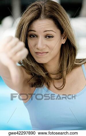 Portrait of a young woman showing thumbs down View Large Photo Image Stock Image - Portrait of a young woman showing thumbs down. Fotosearch