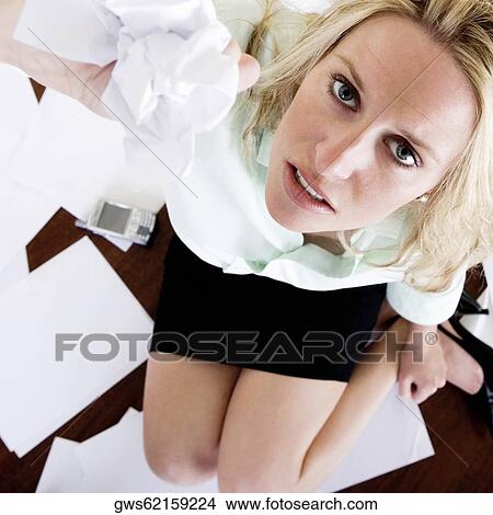 Portrait of a young woman squashing a sheet of paper View Large Photo Image Picture - Portrait of a young woman squashing a sheet of paper. Fotosearch