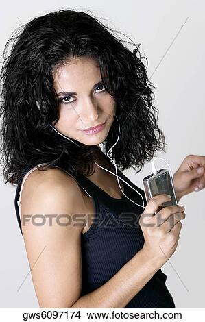 Portrait of a young woman wearing headphones listening to music View Large Photo Image Picture - Portrait of a young woman wearing headphones listening to music. Fotosearch