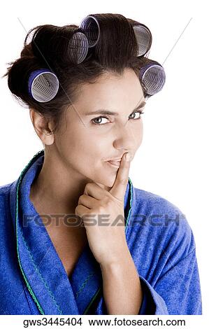 Portrait of a young woman with curlers in her hair and a finger on her lips View Large Photo Image Picture - Portrait of a young woman with curlers in her hair and a finger on her lips. Fotosearch