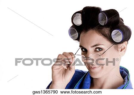 Stock Image - Portrait of a young woman with curlers in her hair adjusting her eyeglasses. Fotosearch