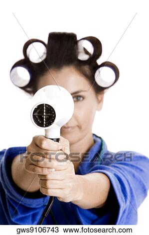 Portrait of a young woman with curlers in her hair holding a hairdryer View Large Photo Image Stock Image - Portrait of a young woman with curlers in her hair holding a hairdryer. Fotosearch