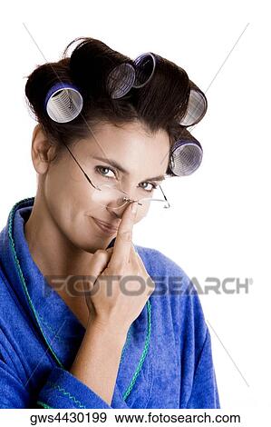 Stock Photo - Portrait of a young woman with curlers in her hair adjusting her eyeglasses. Fotosearch
